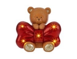 Statuetta di orsetto natalizio in resina che abbraccia un grande fiocco rosso glitterato, illuminato da 7 luci a LED